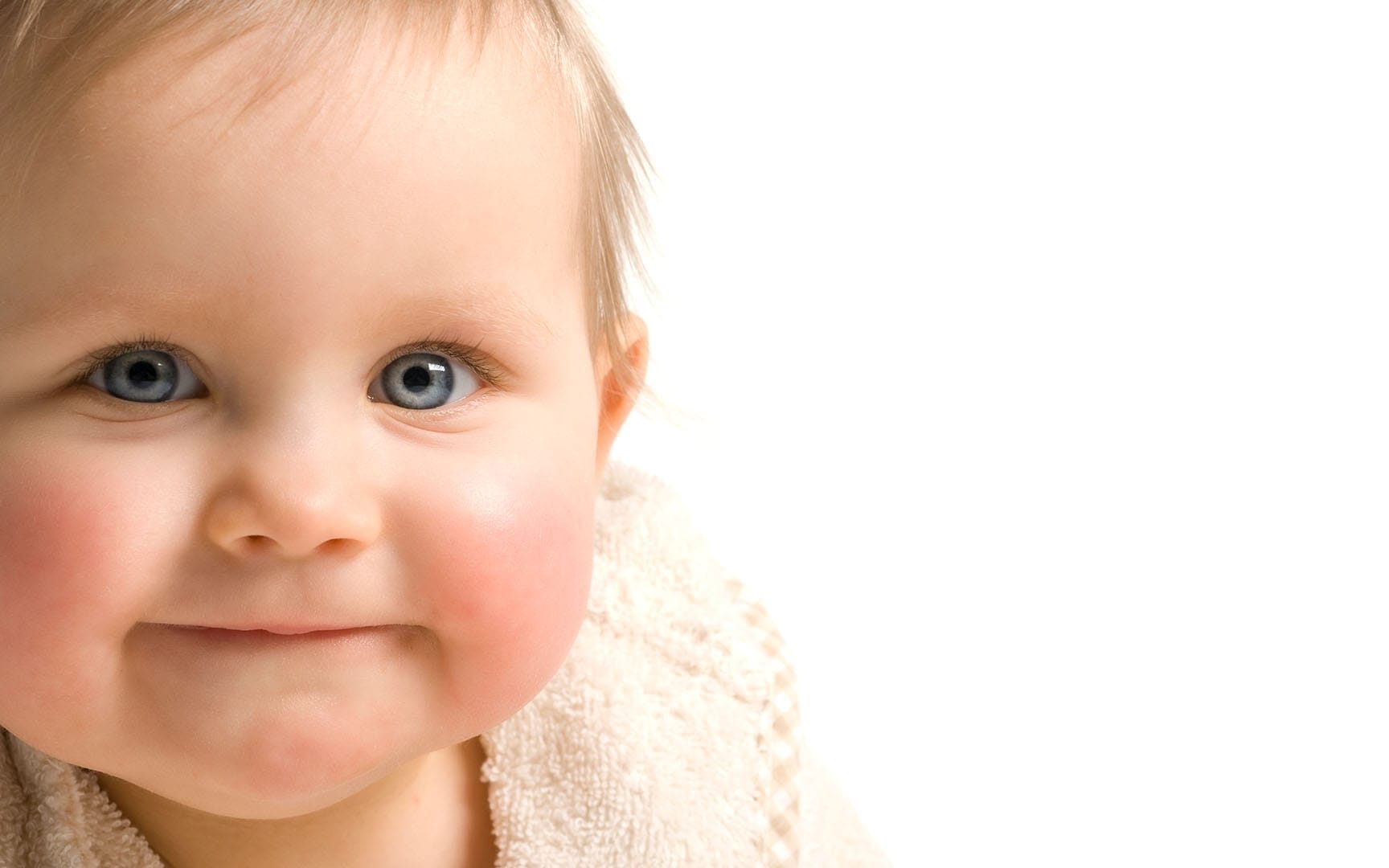 Ein Baby mit blauen Augen blickt in die Kamera.