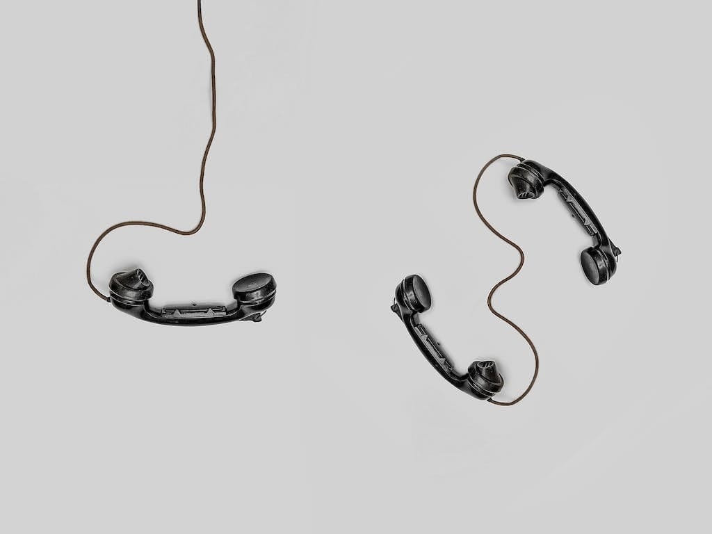 Kontakt zur Hebamme aufnehmen, symbolisiert durch zwei schwarze Telefonhörer.